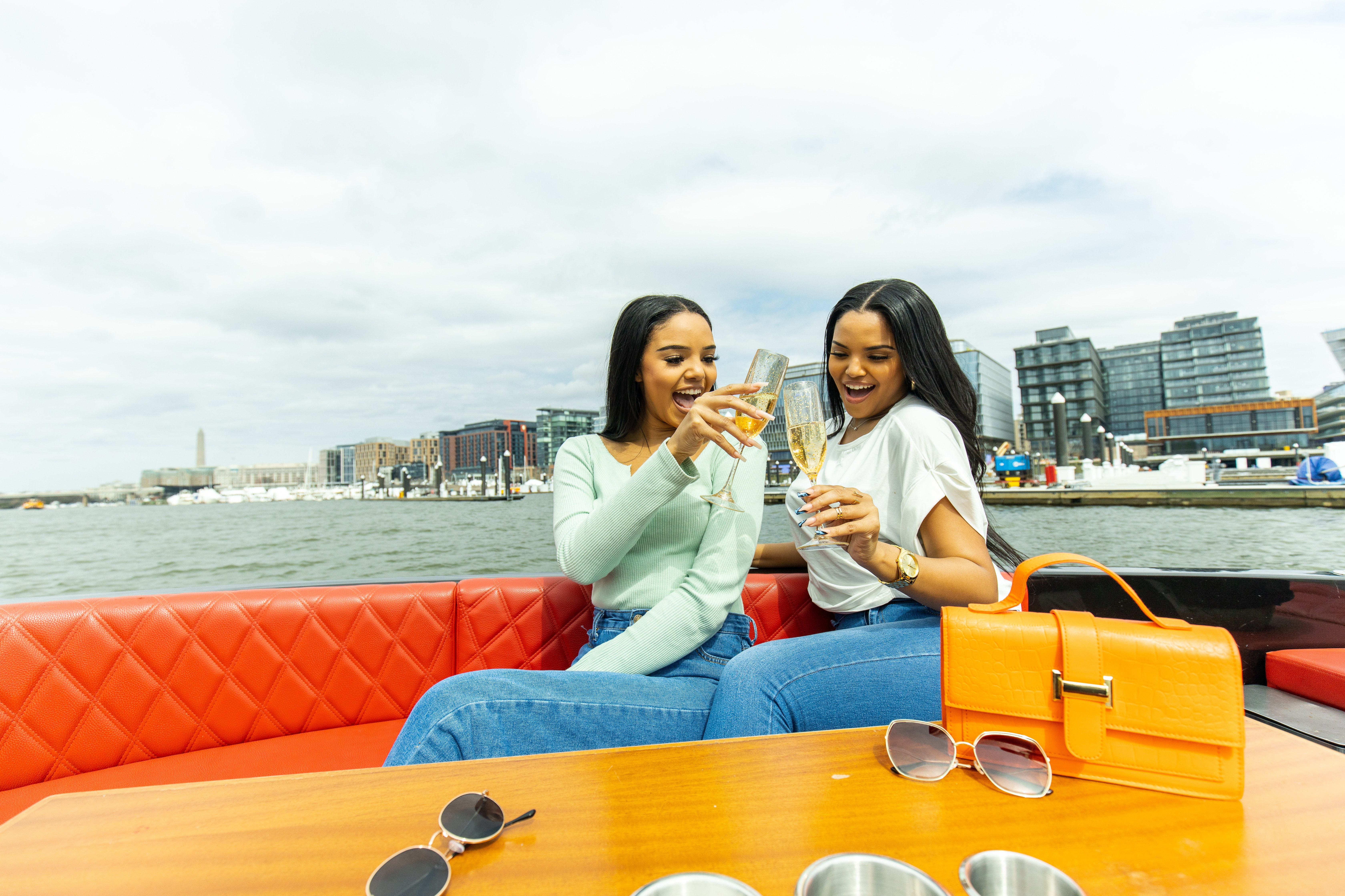 Two guests toasting champagne on a Yachtsy cruise at DC's Navy Yard