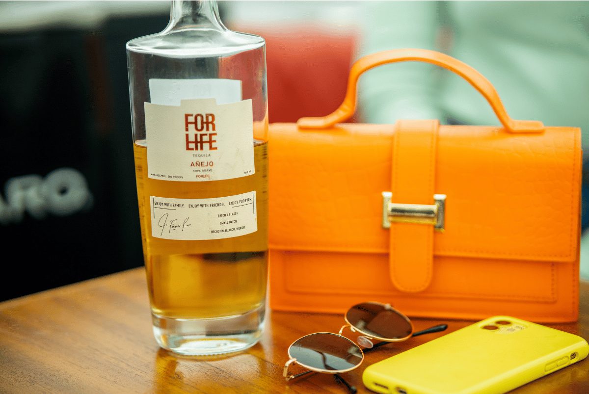 A BYO bottle, sunglasses, and handbag on the wood table of a Yachtsy boat