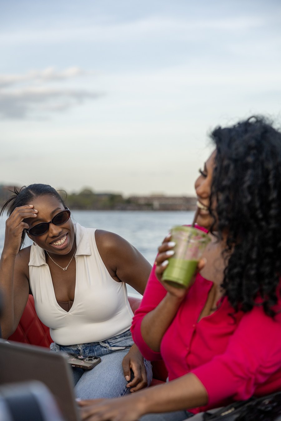 Two friends laughing together aboard a private Yachtsy picnic boat