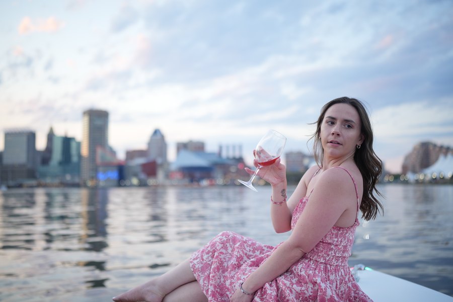 A woman in an elegant gown smiling at golden hour aboard a Yachtsy boat