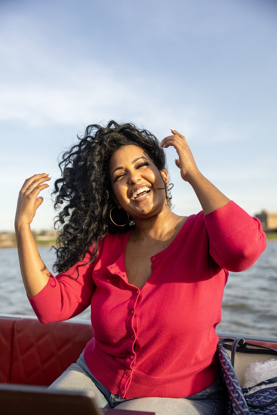 A woman laughing joyfully on a private Yachtsy cruise at golden hour