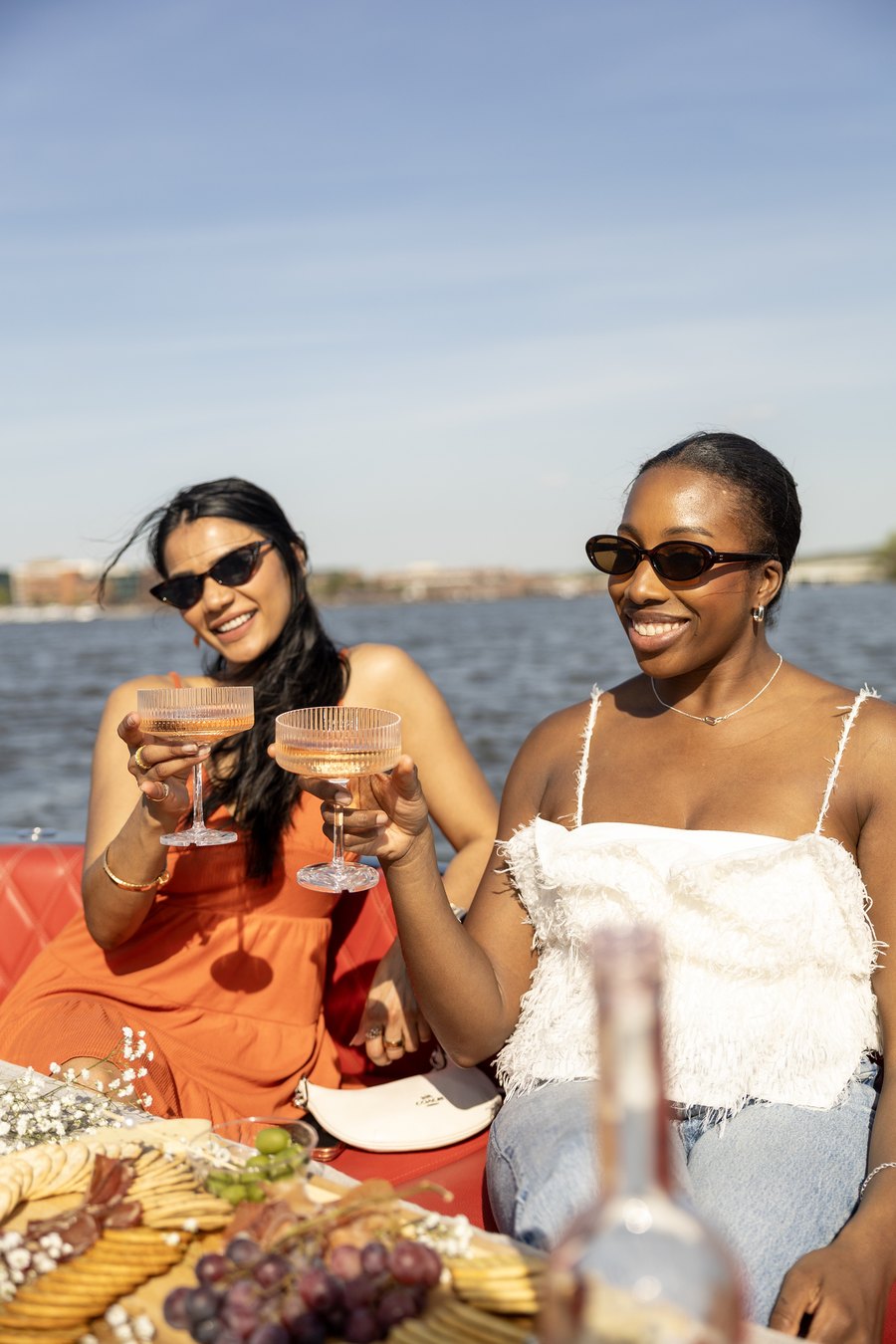 Two guests clinking glasses at sunset on a private Yachtsy boat
