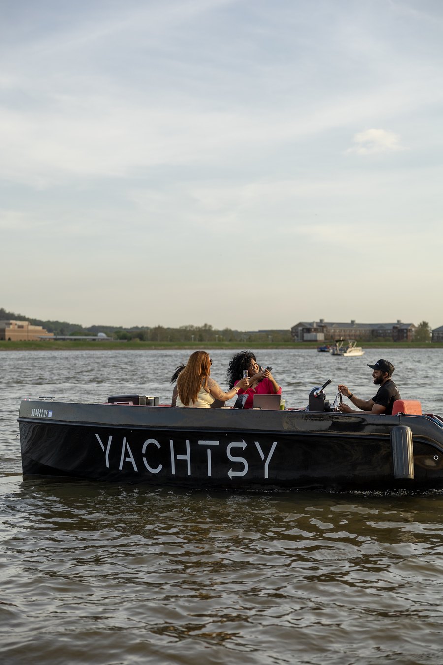 A Yachtsy picnic boat cruising the harbor with the city skyline behind