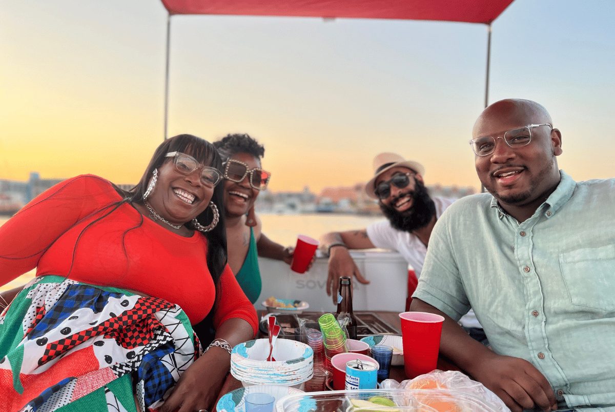 Four friends gathered around the table at sunset on a Yachtsy picnic cruise