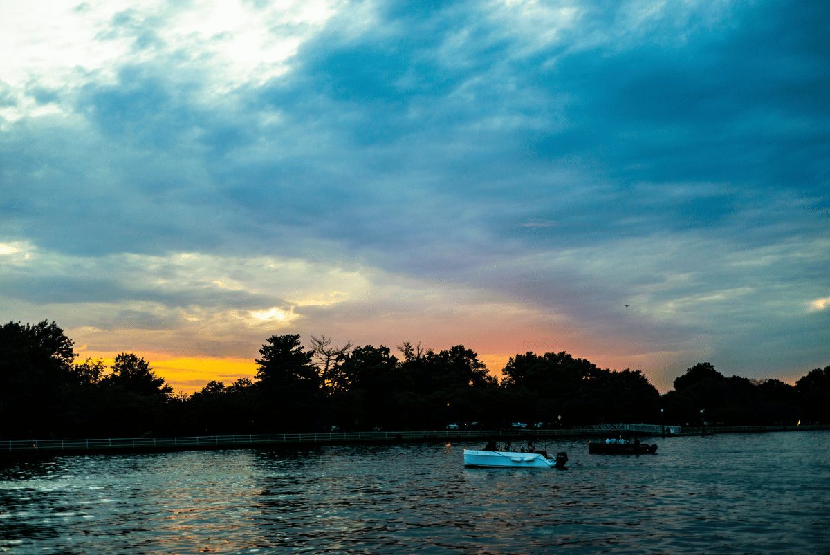 A Yachtsy boat on calm water beneath a glowing sunset sky
